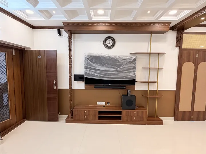 Living room TV wall with walnut cabinetry and open shelves