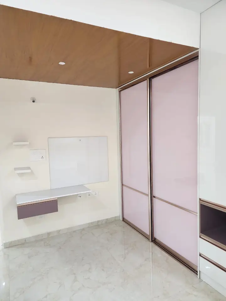 Pink lacquer wardrobe beside a built-in desk