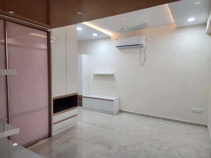 Pink glossy wardrobe doors beside a white TV unit