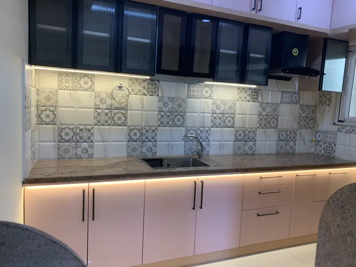 Kitchen counter with patterned tile and under-cabinet lighting