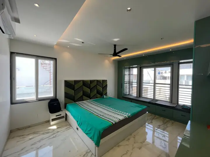 Bedroom with a teal bed and green headboard