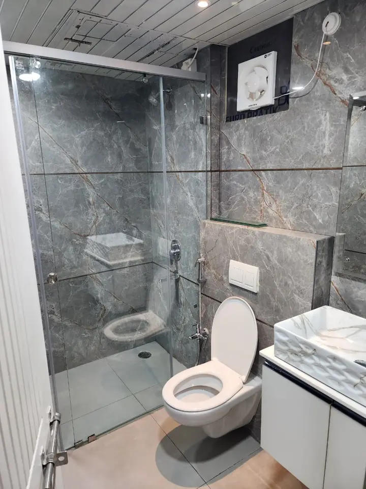 Grey stone bathroom with a glass shower screen