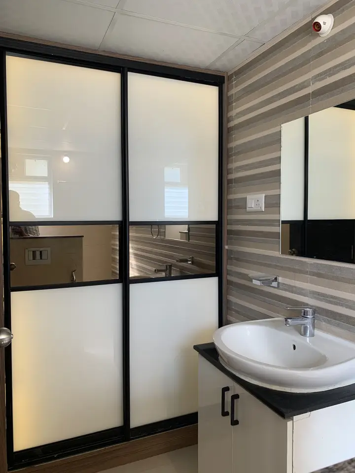 Black framed glass wardrobe beside a vanity
