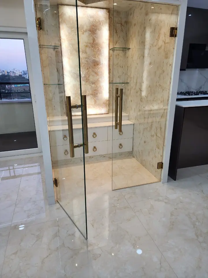 Glass door entrance with brass handles and marble panelling
