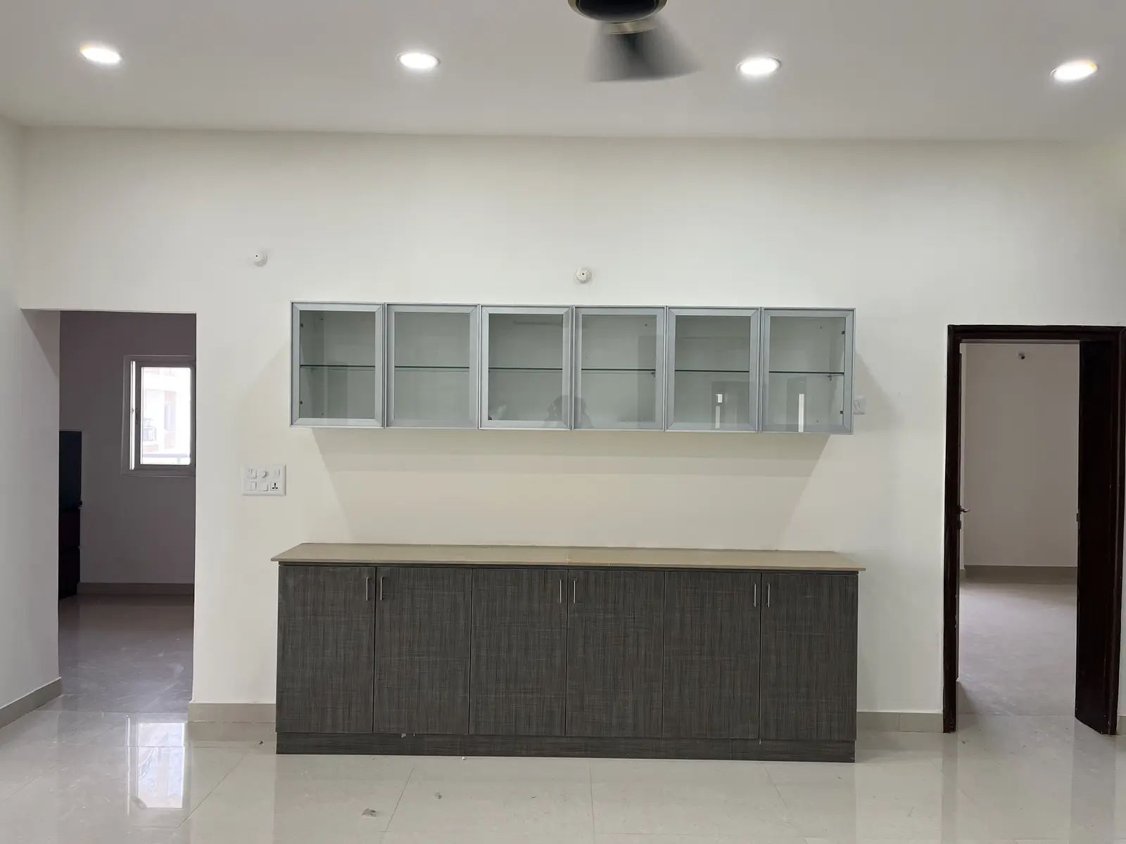 Glass-fronted crockery unit above a grey base
