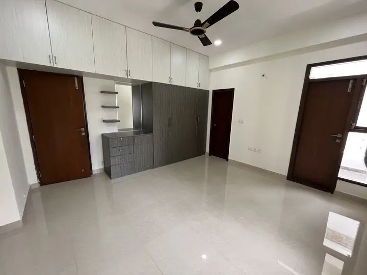 Bedroom with white overhead storage beside a dark door