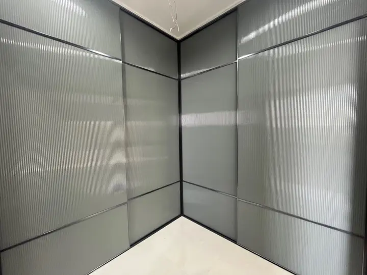 Grey glass wardrobe wrapping a room corner
