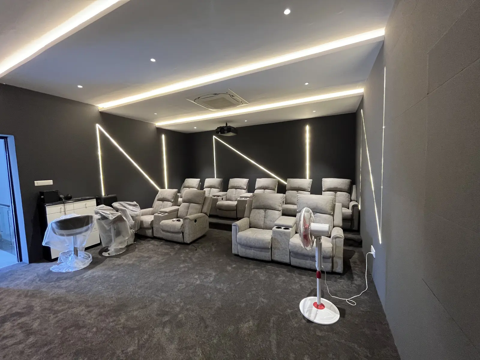 Home theatre with grey carpet and recliner seating