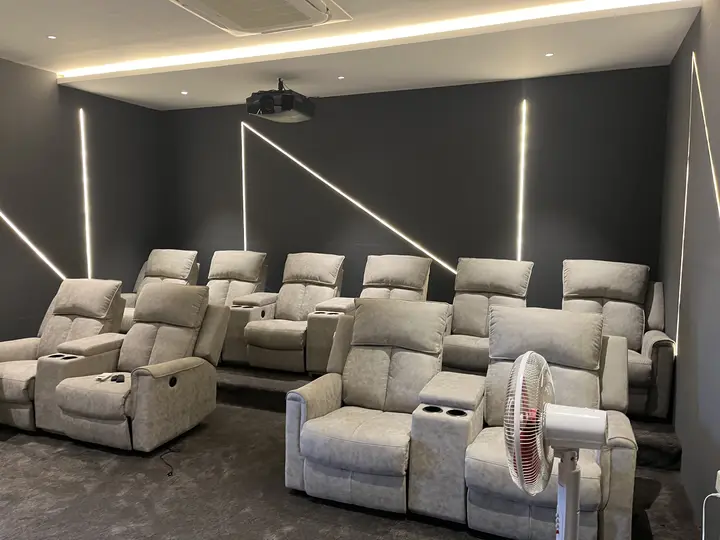 Rows of recliners beneath a lit diagonal ceiling line