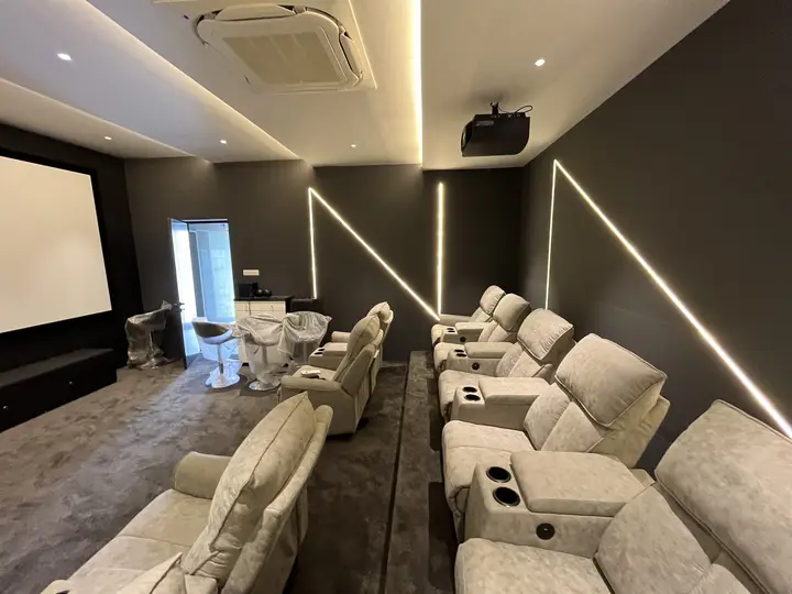 Projector screen with recliners and a ceiling-mounted projector