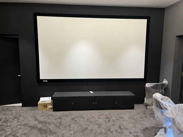 Large projector screen above a low media console