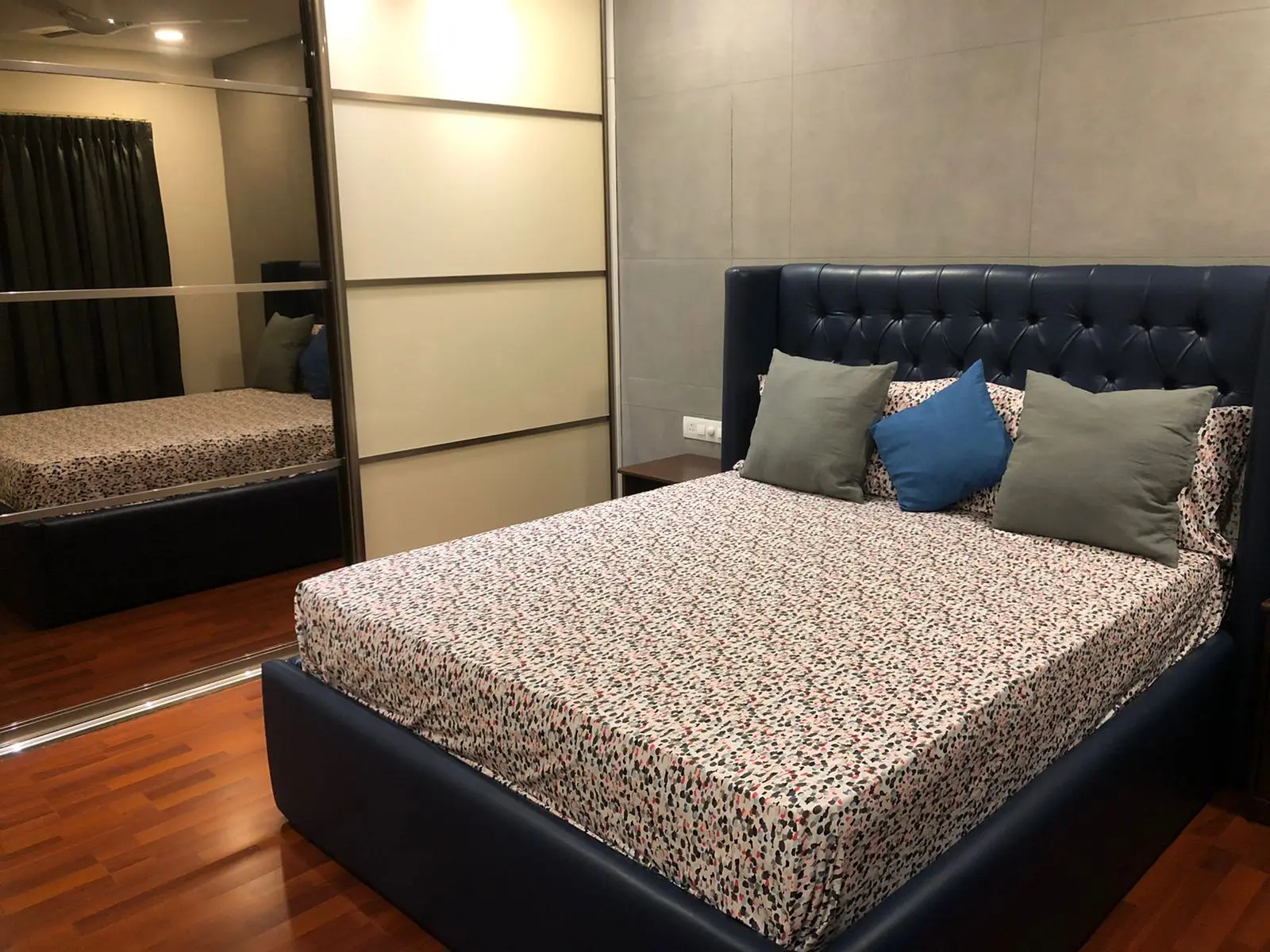 Bedroom with a navy upholstered bed and sliding wardrobes