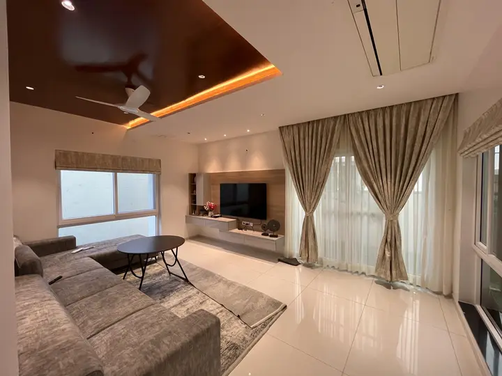 Living room with gold curtains and a lit timber ceiling