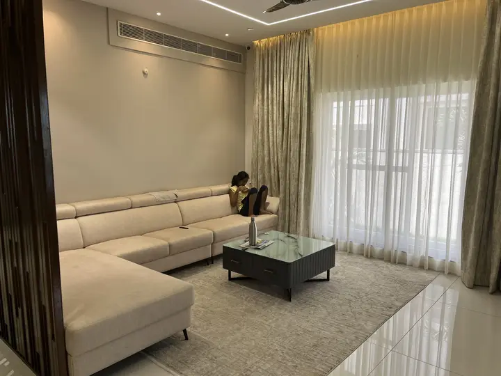Living room with a cream sectional and sheer curtains