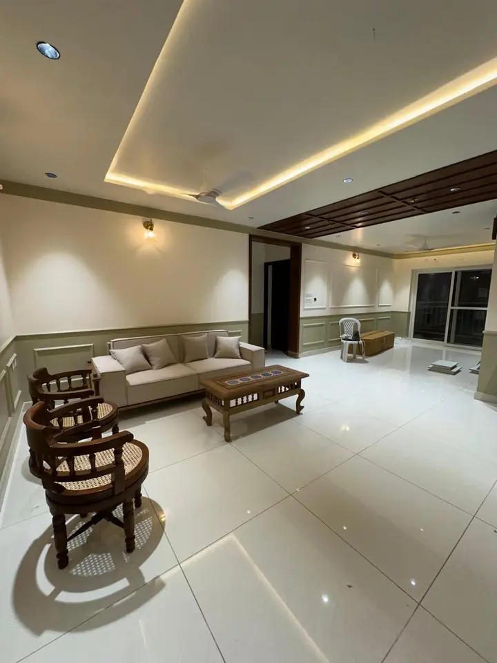 Wide living room with carved chairs and a lit ceiling