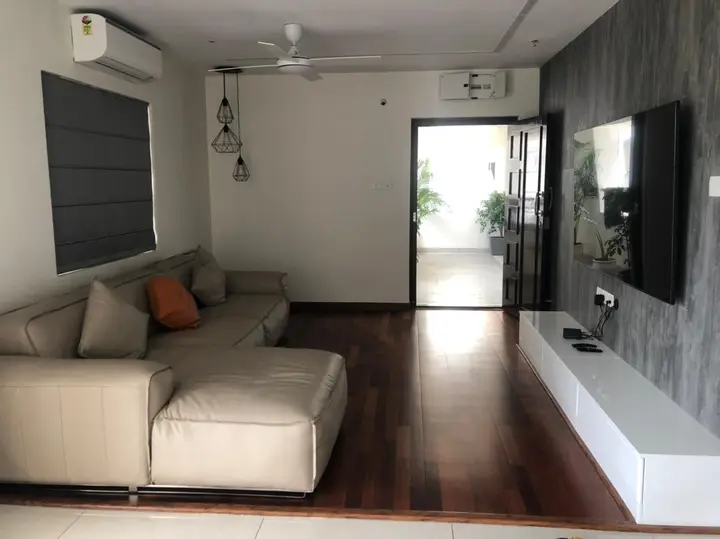 Sofa set against a grey TV wall on timber flooring