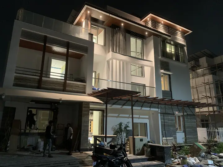 Villa facade at night with timber screens and lit balconies