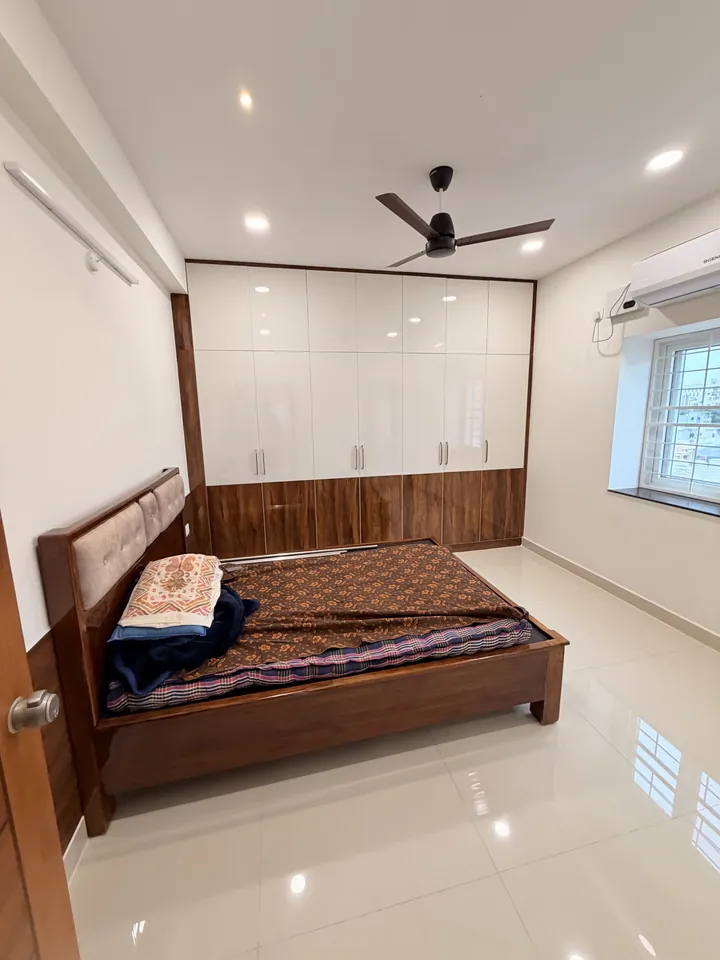 Bedroom with a timber bed and white fitted wardrobes