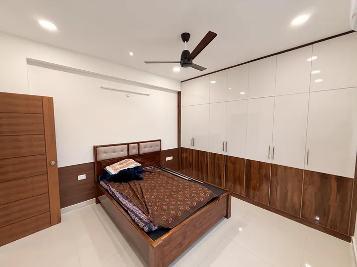 Bedroom with white wardrobes and a timber bed