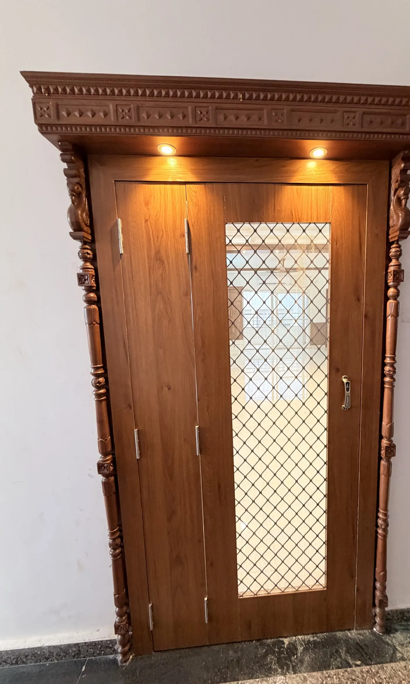 Detailed timber entrance door with a lit patterned panel