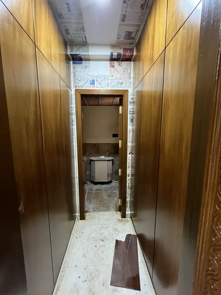 Tall walnut wardrobe doors beside a recessed alcove