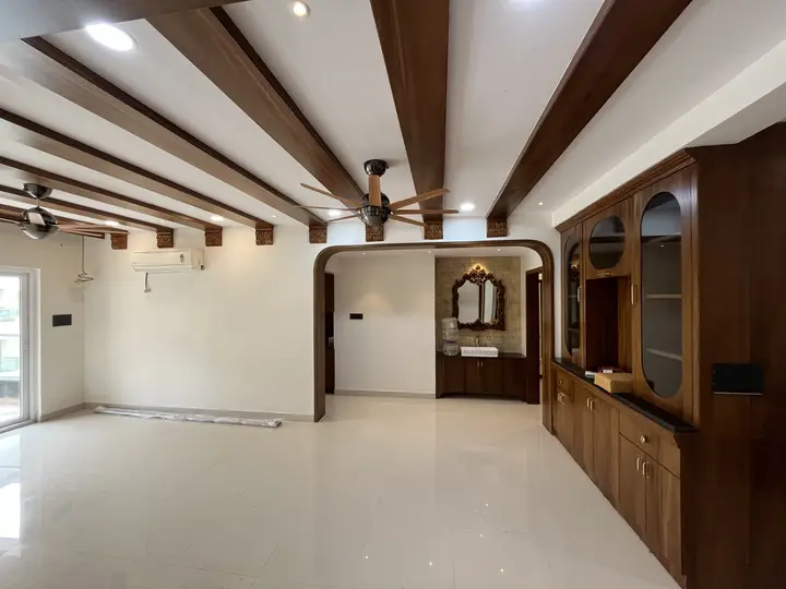 Open living room with exposed timber ceiling beams and walnut cabinetry