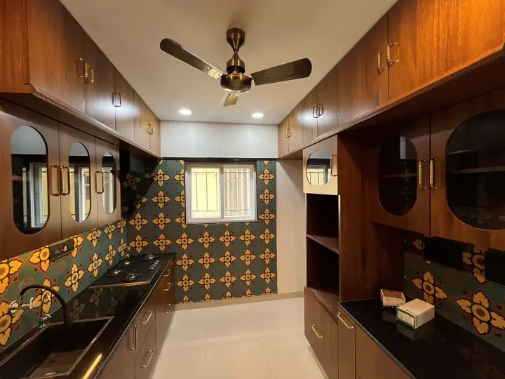Walnut kitchen with black stone worktop and geometric tile