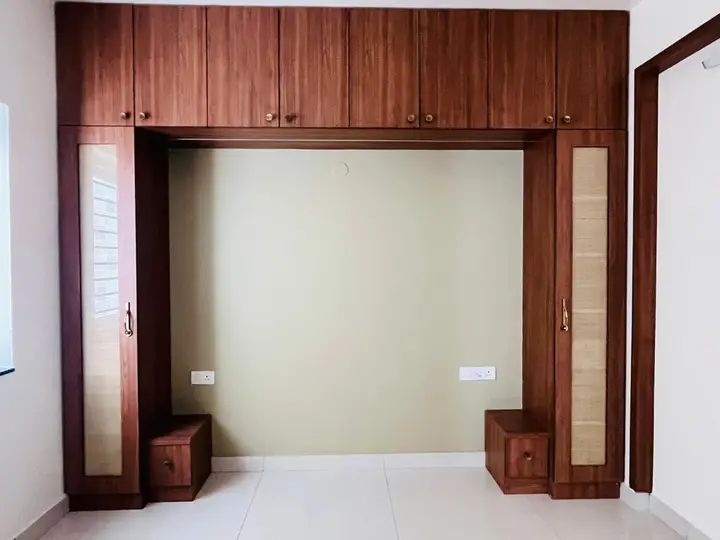 Walnut arched niche with cane-panelled storage