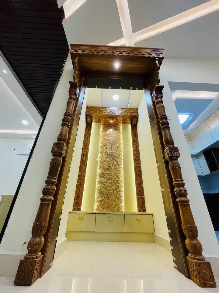 Carved timber pooja unit with a lit gold panel