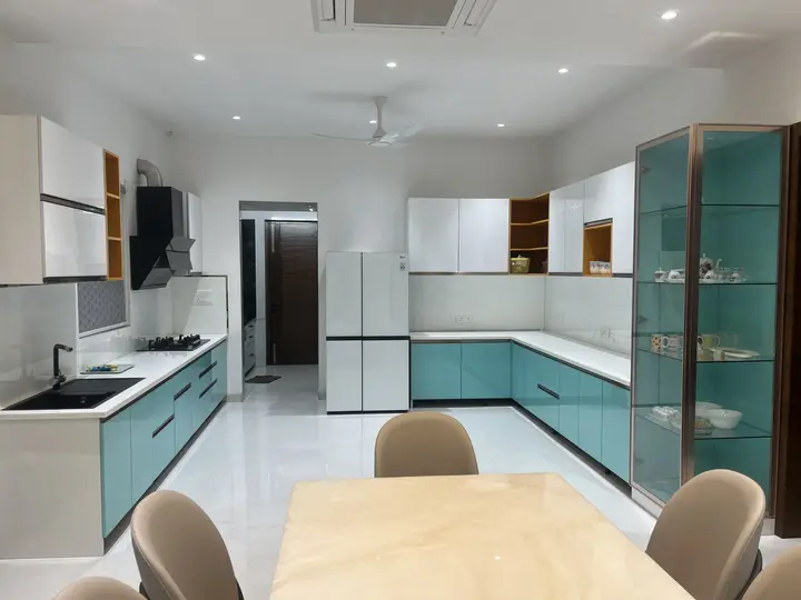 Open kitchen and dining area with teal base cabinets