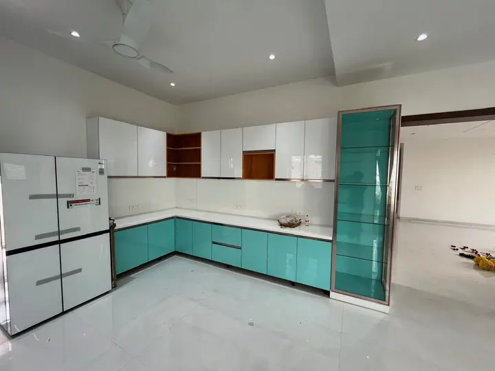 Kitchen corner with white upper cabinets and teal lower units