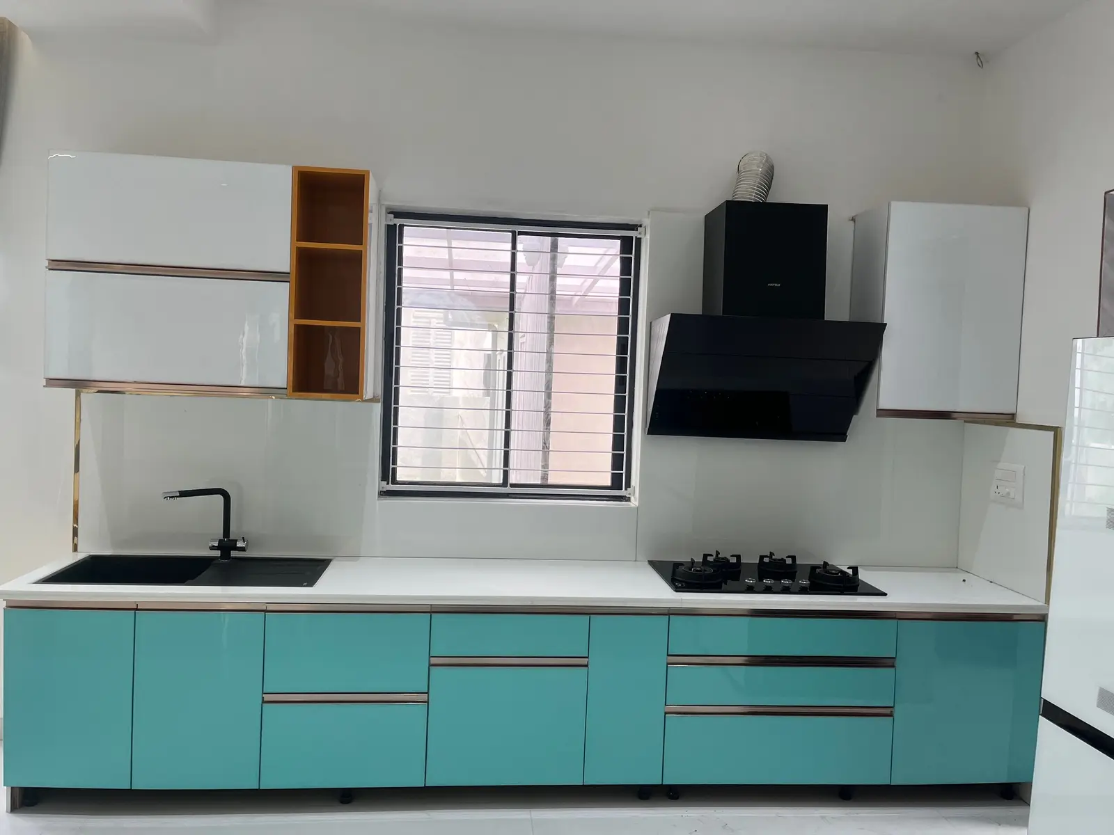Teal and white kitchen counter with a black chimney hood