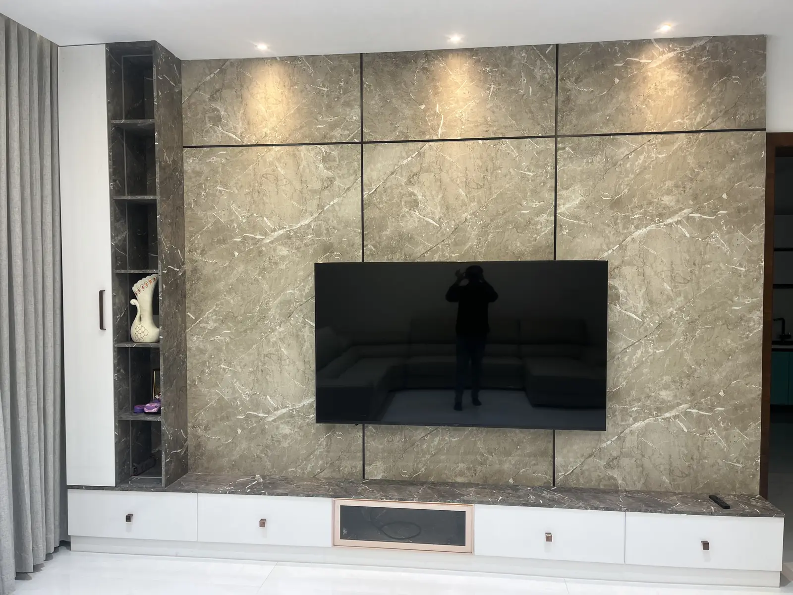 Living room TV wall clad in grey stone panels