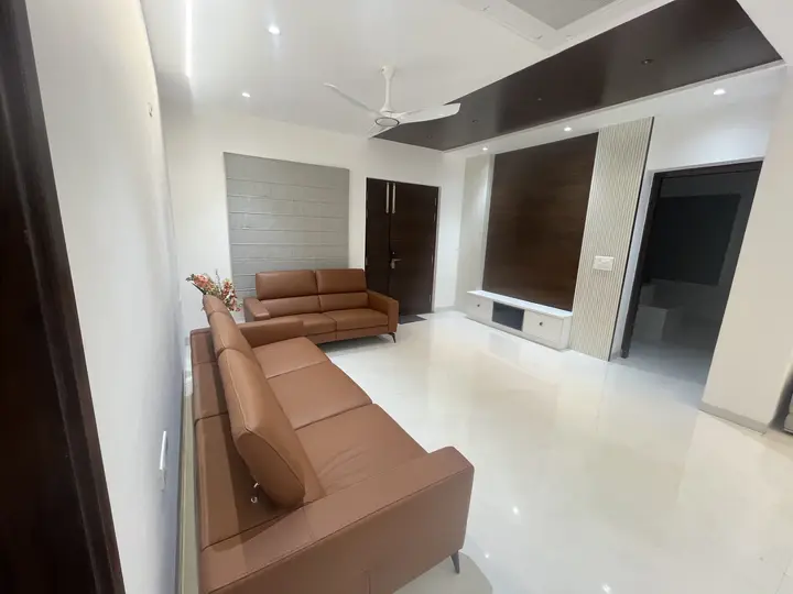 Living room with a tan leather sofa and a dark ceiling drop