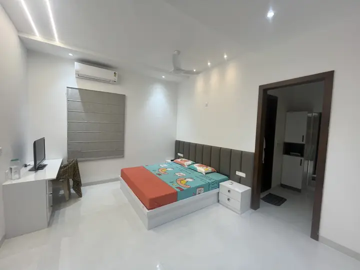 Bedroom with a coral bedspread and built-in desk
