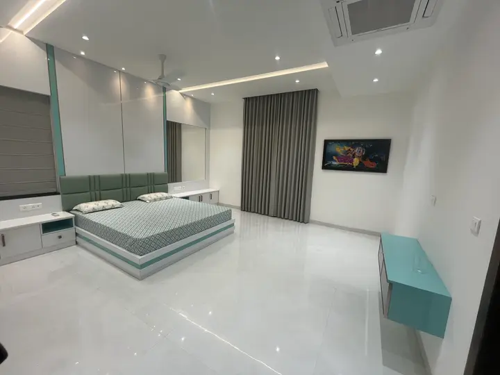 Bedroom with a teal bed panel and a lit ceiling line