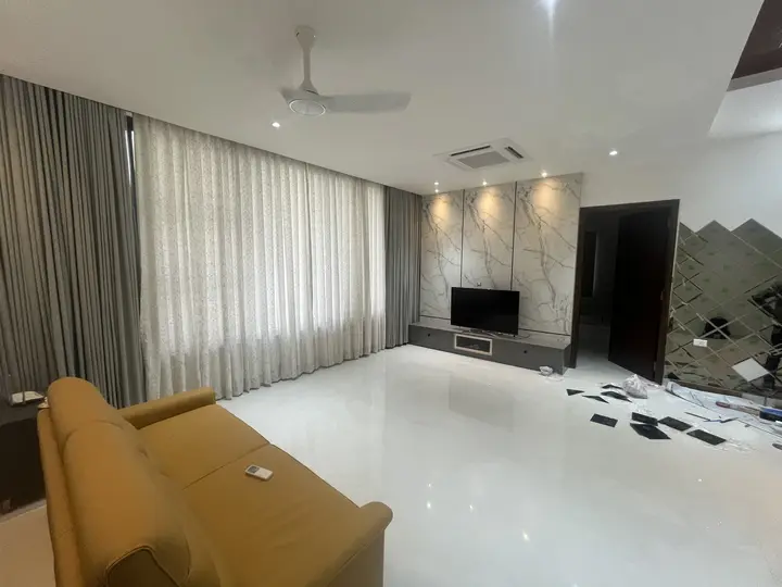 Living room with a mustard sofa and stone feature wall