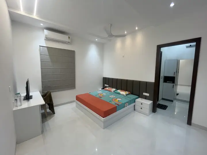 Bedroom with an orange bedspread and open doorway