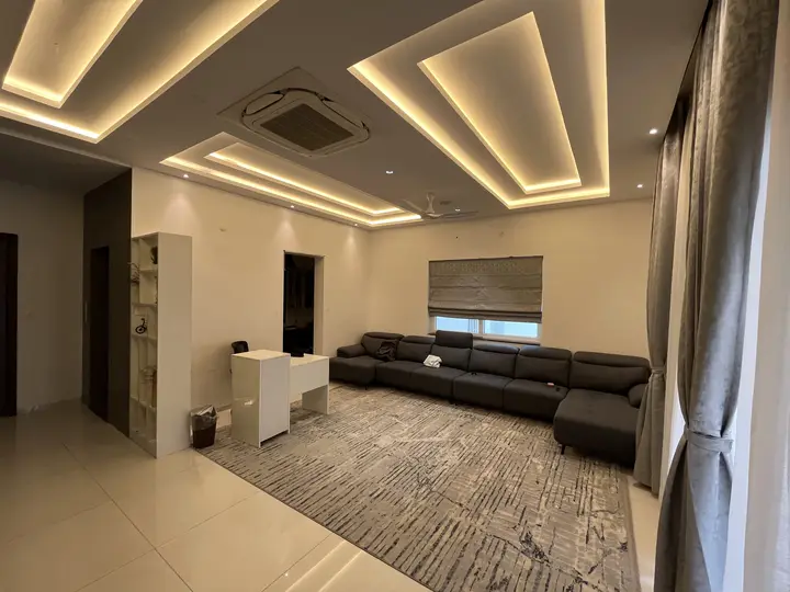 Living room with a grey sofa and a lit coffered ceiling