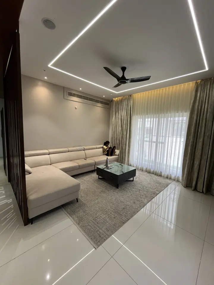 Cream sectional in a living room with recessed light lines
