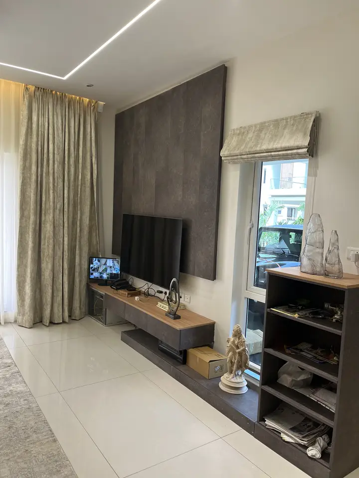 TV unit with dark shelves against a grey feature wall