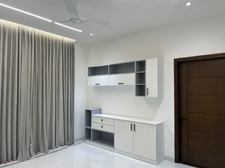 White wall unit and grey curtains beside a timber door