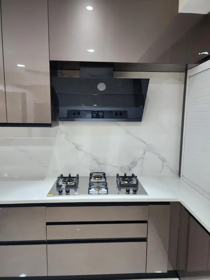 Marble backsplash with a gas hob and black chimney
