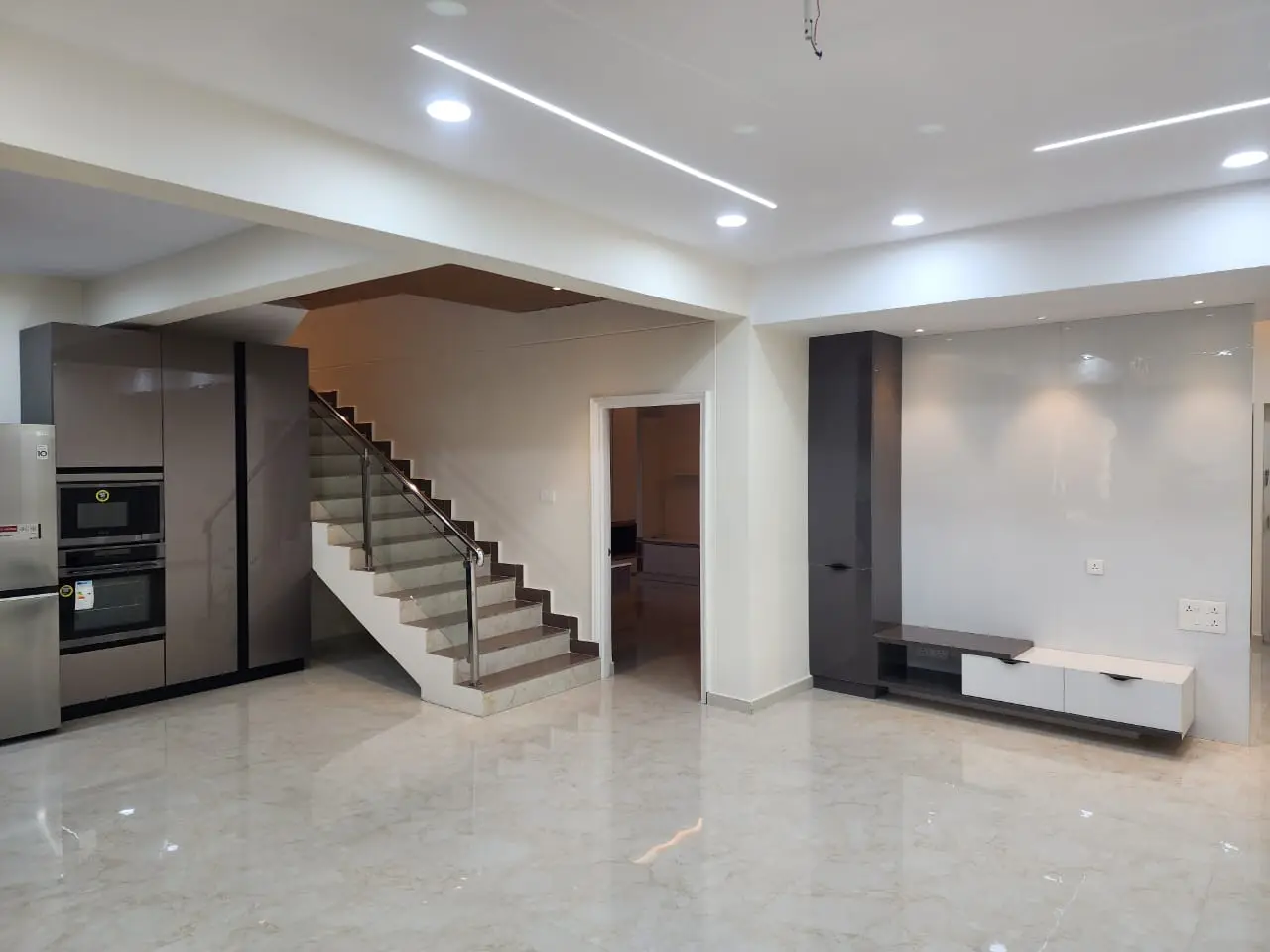 Staircase and open living area with a floating TV unit